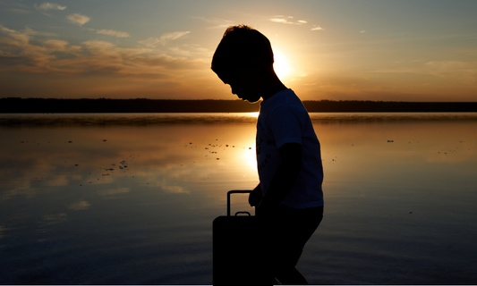 A silhouette of a child with a suitcase