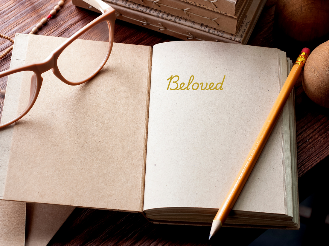 an open journal with “Beloved” written in gold script