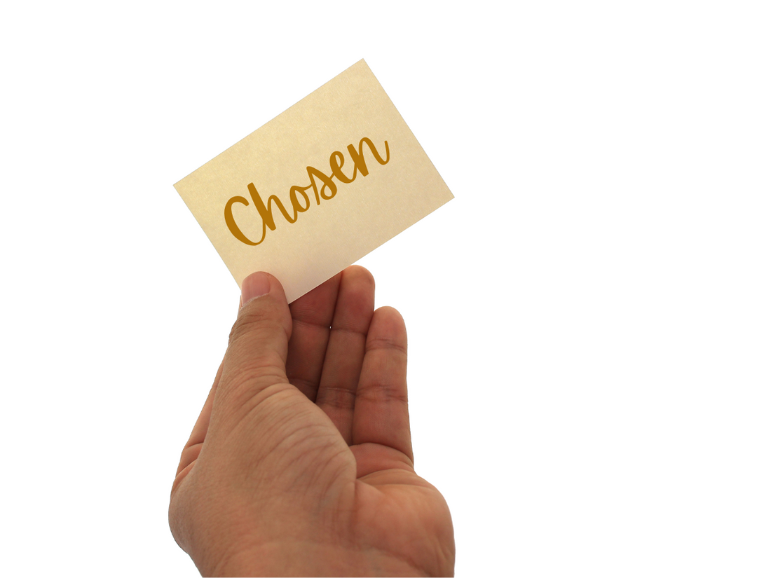 hand holding a tag that says "chosen"