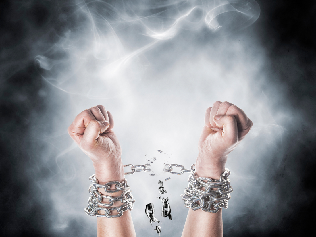 hand raised with chains broken