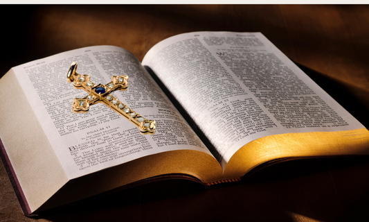 An open Bible with a cross pendant resting on it