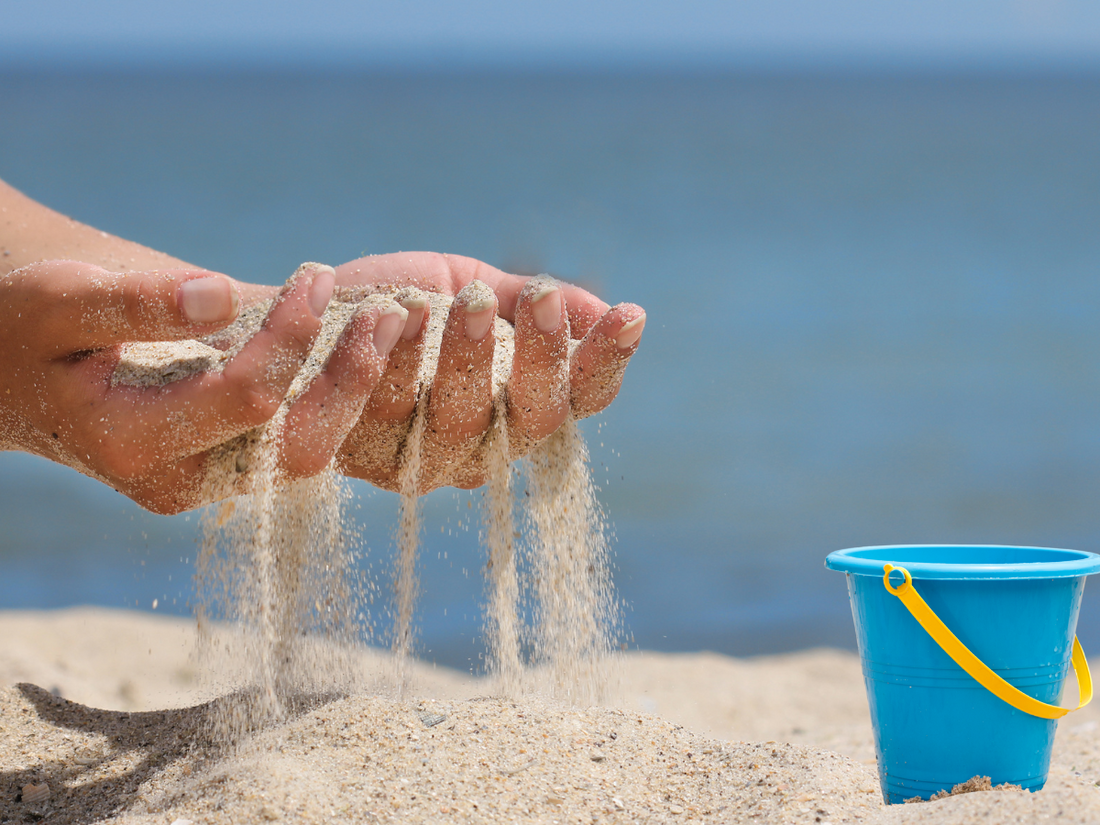 hand with sand running through fingers