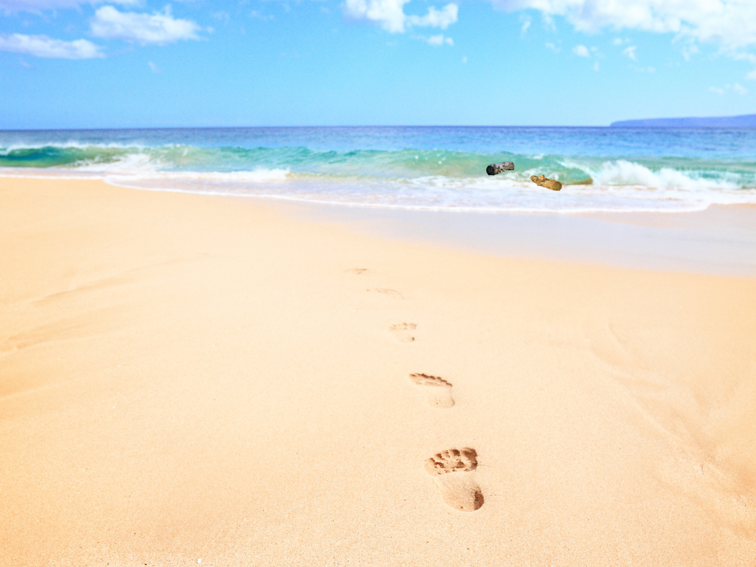 Footsteps on the sand leading to the horizon