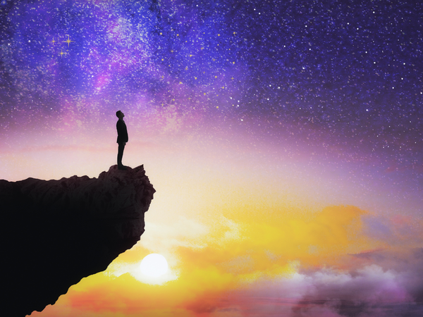 someone standing on a cliff looking up