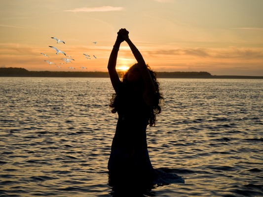 a female kneeling in the sea
